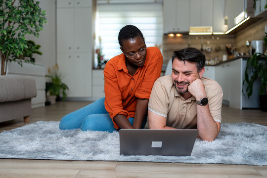 Couple enjoys time together while working on laptop in cozy home setting