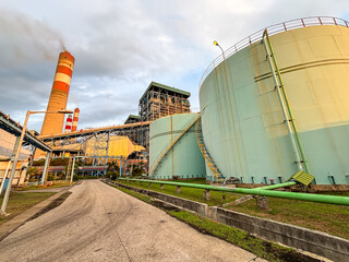 Obraz premium Industrial Landscape Power Plant, Storage Tank, and Chimney Stack