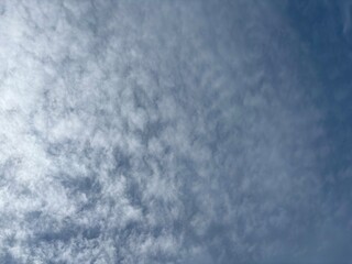 Full frame background texture of mid-level altocumulus or cirrocumulus clouds in a mackerel sky pattern, showing atmospheric conditions.