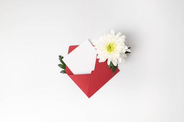 One red envelope, white card, and white flower on white background. Valentine's Day, Mother's Day, Women's Day, Wedding, Anniversary, or Birthday.  Flat lay with copy space.
