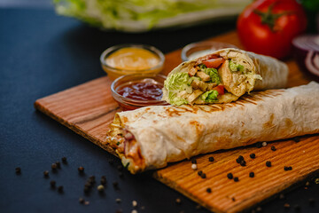 Grilled chicken wraps with fresh lettuce, tomato, and dipping sauces