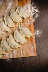 Homemade dumplings on wooden surface with flour dusting