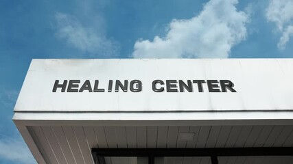 Healing Center word sign clearly displayed on the holistic or medical building facade beneath a clear blue sky, signifying a facility dedicated to promoting wellness, recovery, and therapeutic service