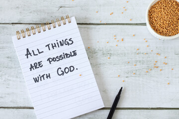 All things are possible with God, handwritten quote in a notebook with mustard seeds. Top view. Faith and trust in Jesus Christ, biblical concept.
