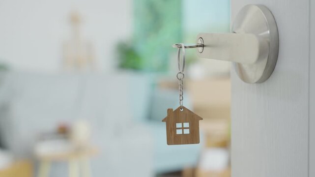 Moving house, relocation. The key was inserted into the door of the new house, inside the room was a cardboard box containing personal belongings and furniture. move in the apartment or condominium