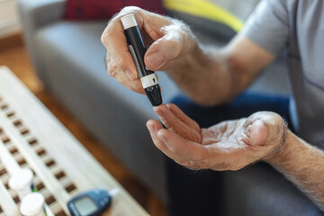 Obraz premium House, hands and man with diabetes machine, testing for glucose levels and chronic disease. Closeup, apartment and person in living room, medical and sugar with insulin, monitor and hypertension.