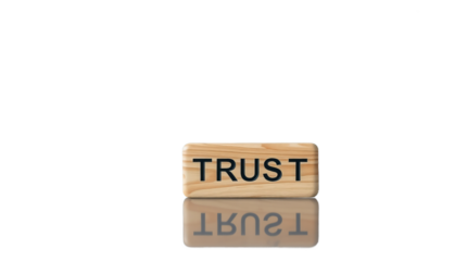 Word of Trust: A solitary wooden block, bearing the word TRUST in bold letters, stands out against a minimal background, embodying the cornerstone of relationships. Reflecting this core belief