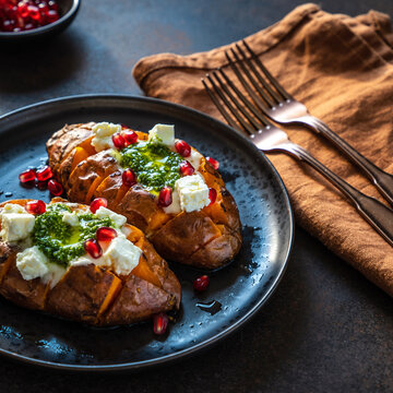 Pieczone bataty z fetą, pesto i granatem.