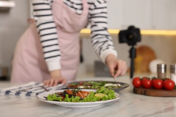 Woman creating composition for shooting in studio, focus on meal. Professional food photography