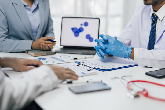Doctors discussing medical report with patient information during meeting.