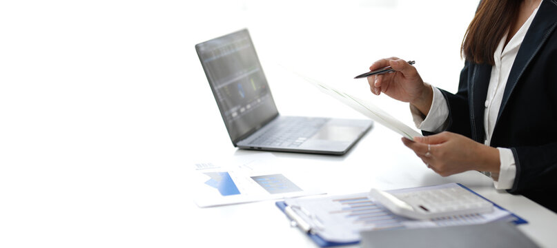 Businesswoman reviewing financial reports and using laptop for data analysis, optimizing business strategies for maximum profitability in corporate.