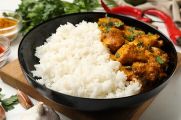 Chicken tikka masala with rice served on white marble table, closeup