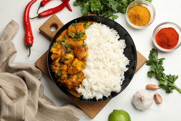 Chicken tikka masala with rice served on white marble table, flat lay