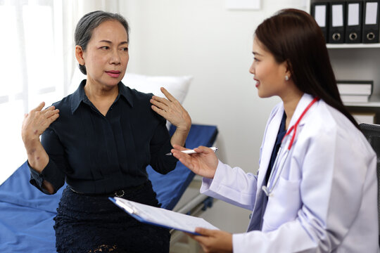 Senior patient describing symptoms to doctor in hospital room. - Powered by Adobe