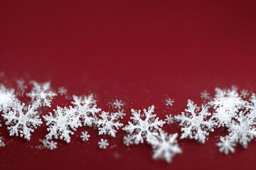 Soft focus white snowflakes scattered across a deep red background creating a festive winter holiday border