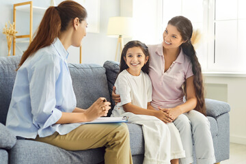 Family and counselor in therapy session support. A psychologist meets with mother and child girl in...