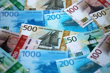 Norwegian Krone currency money bills. NOK currency banknotes in pile with different denomination close up
