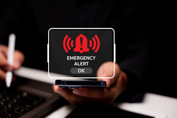 A person holding a smartphone displays an emergency alert notification, emphasizing the importance of timely communication during crises.