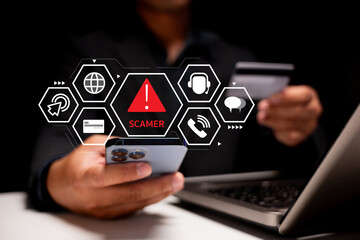A person holds a smartphone displaying a warning about scammers, with digital icons representing online threats and security.