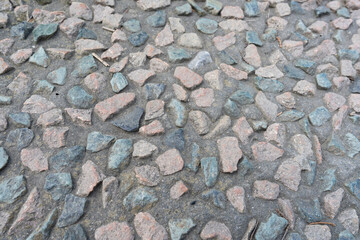 The road surface is red and gray, with irregular stones embedded in the cement.