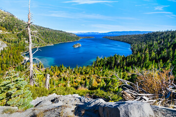 Emerald Bay Lake Tahoe California USA panoramic view of blue lake water surrounded by green pine forest and Sierra Nevada mountains under clear sky popular travel and nature destination