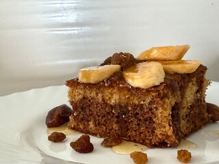 A geographic chocolate pie decorated with banana slices, raisins, dates, and drizzled with honey. Making delicious homemade baked goods.