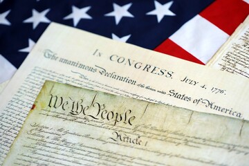 Constitution of the USA with US flag. Aged historical documents Washington DC on American Declaration of independence