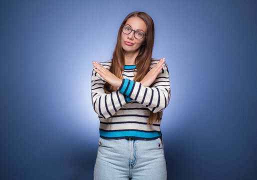Limit. Woman gesturing stop or x sign with her arms, refuses or reject something, girl crossing her hands, isolated on blue background.