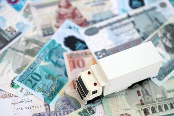 Egyptian pound currency money bills and toy delivery truck close up. The concept of delivery and logistics