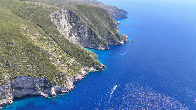 Aerial drone of scenic rocky tropical seascape with white steep limestone cliffs creating a blue lagoon with sea caves and turquoise crystal clear beaches visited by luxury yachts and sailboats