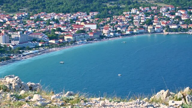 Panoramic coastal cityscape overlooking turquoise waters and vibrant urban buildings. Ba&scaron;ka, Krk island, Croatia