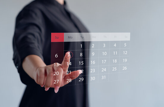 Businesswoman touching digital calendar interface for scheduling and appointment management. Concept for time planning, productivity, reminder, and modern technology organization.