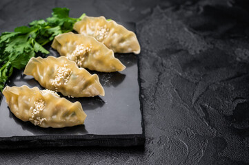 Steamed Japanese Gyoza Dumplings with meat and vegetables. black background. top view