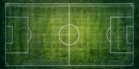 Bird's eye view of a green soccer field with white markings in bright sunlight