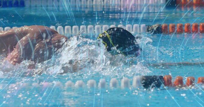 Athlete wearing black cap goggles performing front crawl in pool lane with lane dividers, splashes