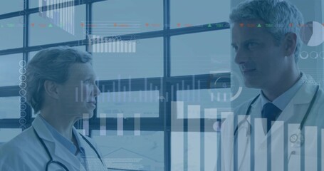 Two doctors discussing data in research lab, with stethoscopes and digital charts on large windows