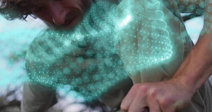 Leaning forward man studying holographic turquoise point-cloud mesh outdoors, augmented reality