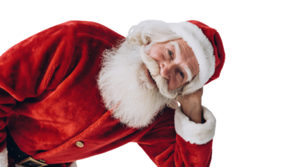 Santa claus in red suit and hat leaning on his hand with a white beard and smiling gently at the viewer