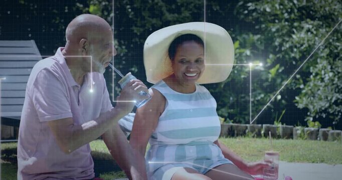 Senior couple clinking mason jars poolside, splashing water into animated droplets for marketing