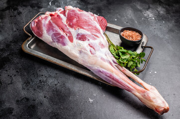 Uncooked whole mutton leg, raw organic lamb meat. black background. top view