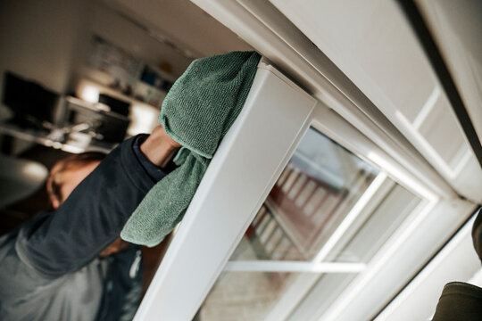 Professional window cleaning with squeegee and microfiber cloth on residential building