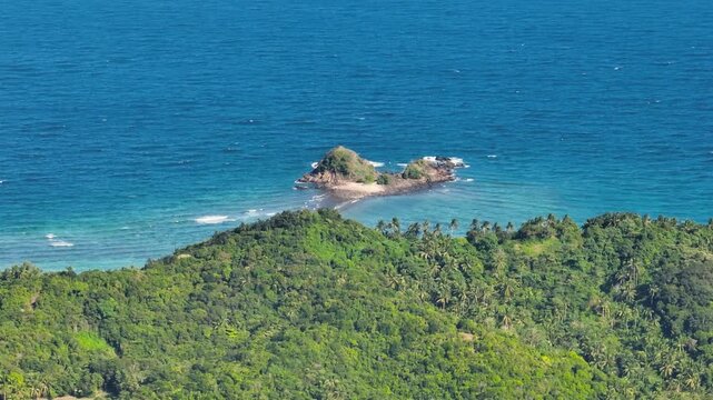 Puro Islet surrounded by waves and blue sea. Santa Fe, Tablas, Romblon, Philippines.