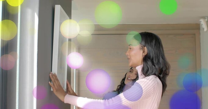 Friends consulting spirit level and aligning picture frame on entryway wall for DIY decorating