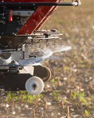 Tractor spreading artificial fertilizers in field