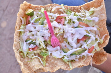 Fresh, vibrant tostada with creamy dressing, avocado, and fresh toppings ready to eat for a delicious meal