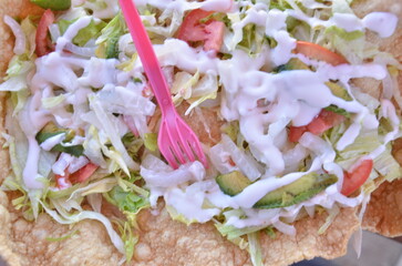Fresh, vibrant tostada with creamy dressing, avocado, and fresh toppings ready to eat for a delicious meal