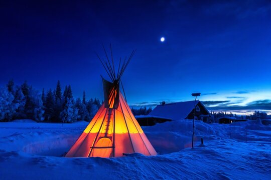 Yurt in the snow illuminated from within. tent at night in winter