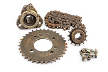 An old motorcycle sprocket and chain, thickly coated in black oil and grease, on a white background. Perfect for motorcycle repair and maintenance topics.
