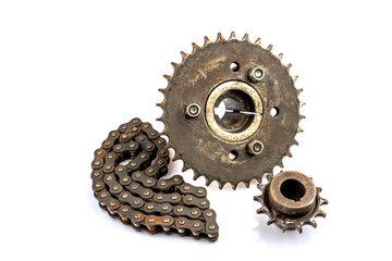 An old motorcycle sprocket and chain, thickly coated in black oil and grease, on a white background. Perfect for motorcycle repair and maintenance topics.