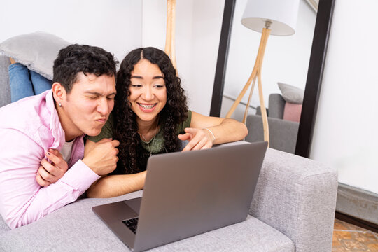 Young couple watching content on laptop together - Powered by Adobe